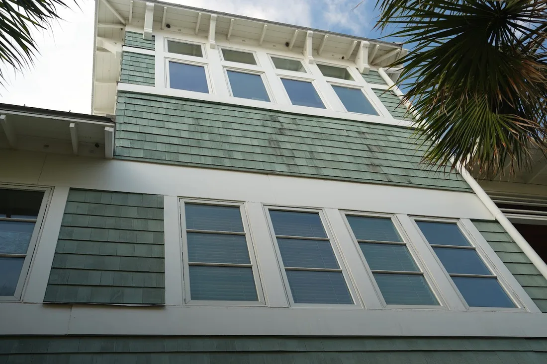 Coastal beach house facade with rows of freshly cleaned windows