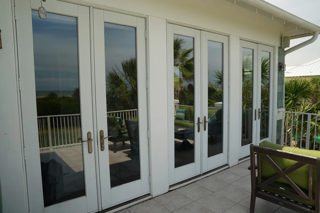 Streak-free French doors reflecting the ocean after a Clarity cleaning